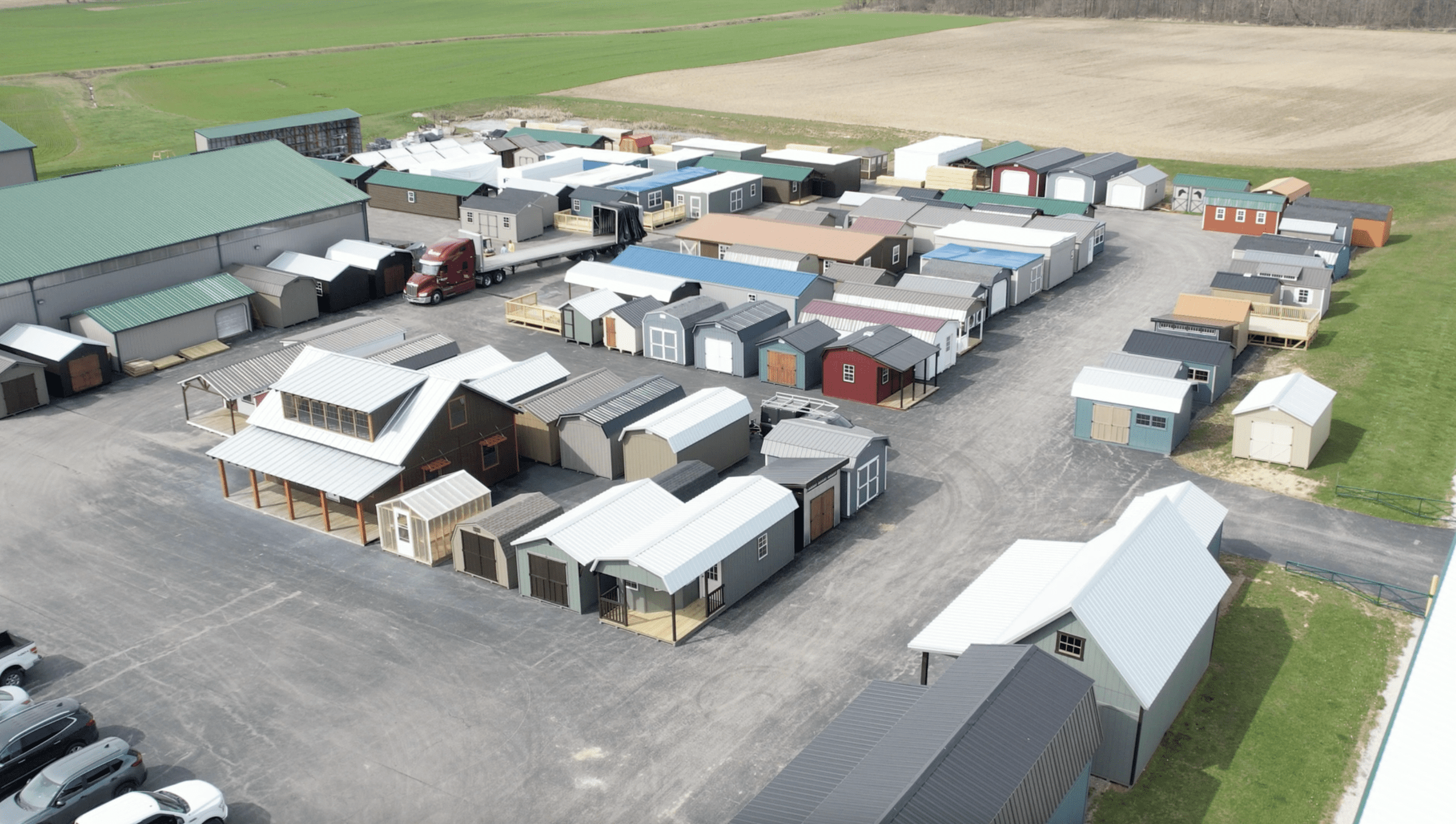 Birds eye view of inventory lot. Lot is filled with cabins and sheds of variable colors and shapes.